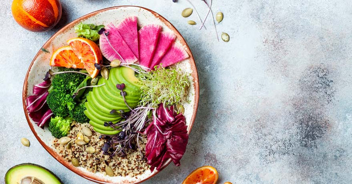 Colorful, sliced avocado, beet, oranges and greens on a plate