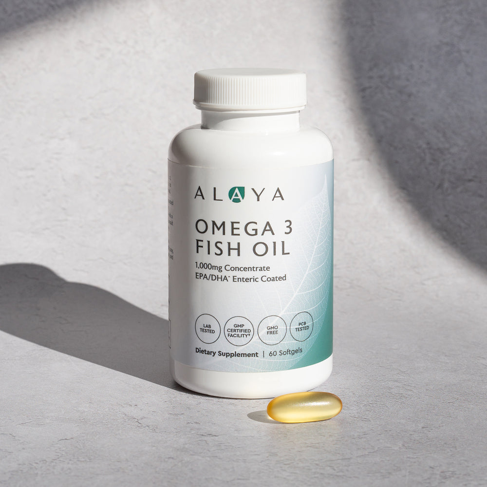 Alaya Omega 3 Fish Oil supplement bottle on a gray background with a softgel beside it
